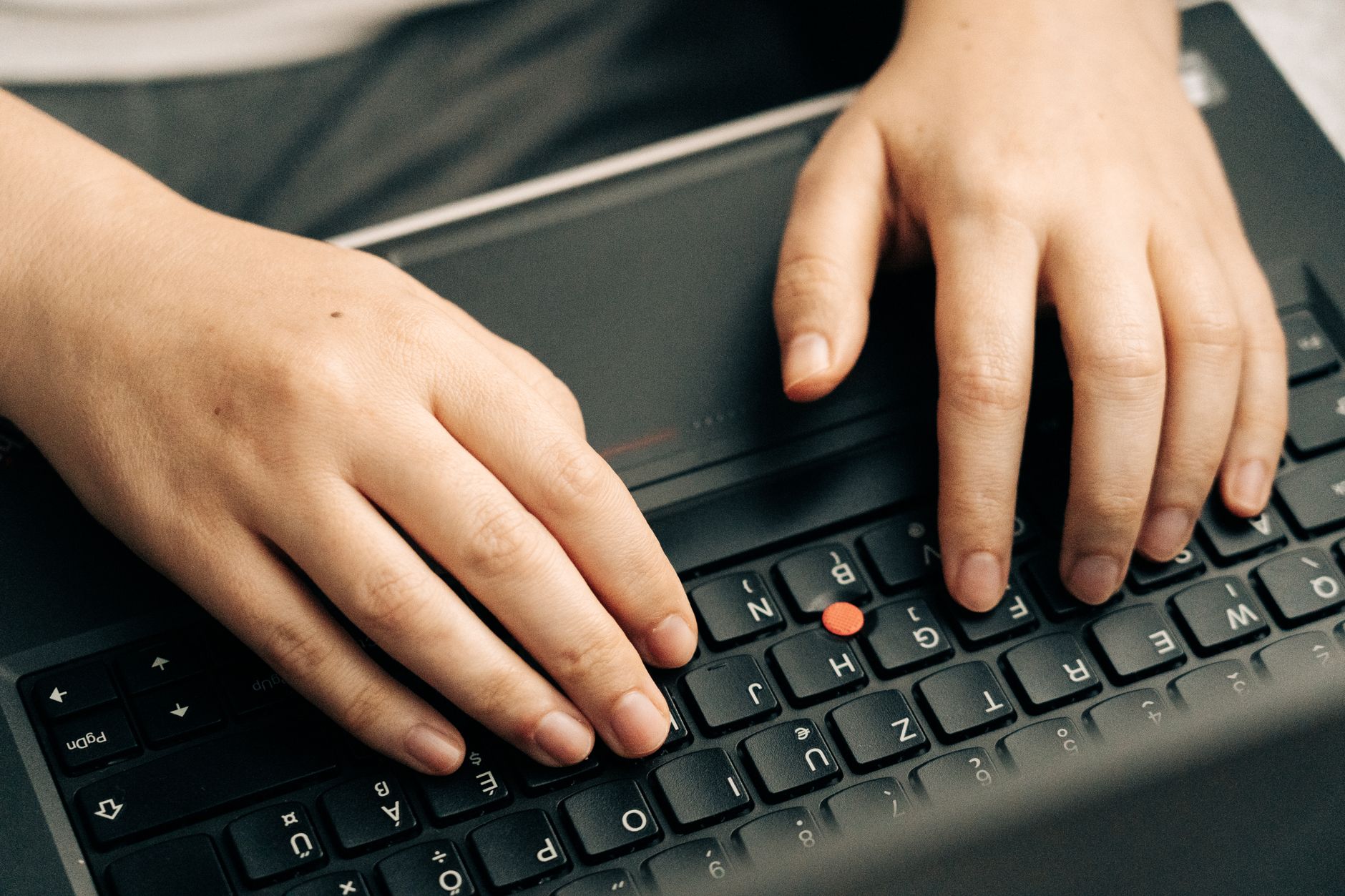 Mains sur un clavier d'ordinateur lors d'une saisie de mot de passe